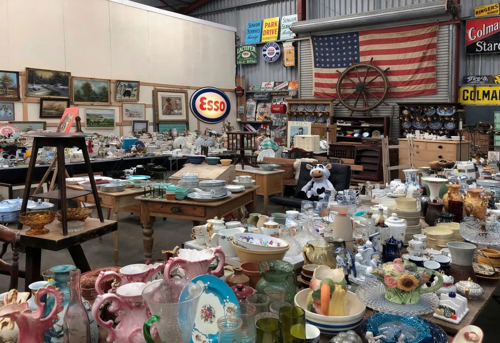 Antiques, dishware, and collector finds displayed at an estate sale.